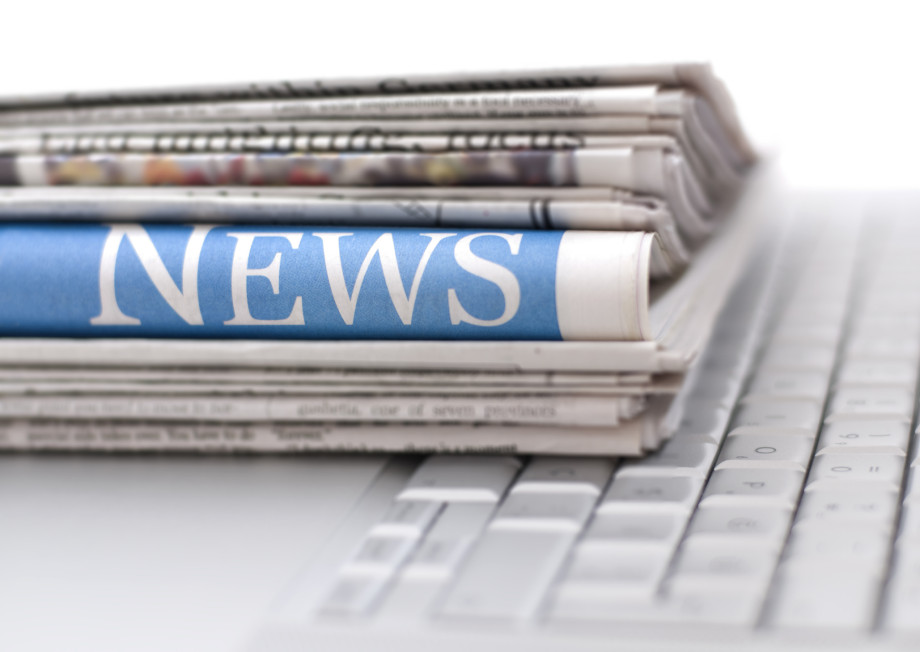 A pile of folded newspapers. The word 'news' can be read on the fold of one of them.