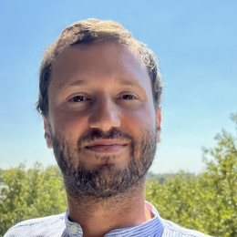 Smilende mann . Himmel og skog i bakgrunnen.