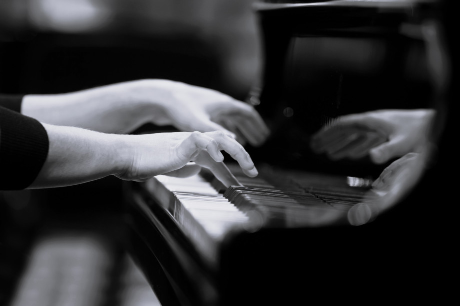 Hendene til en dame som spiller piano