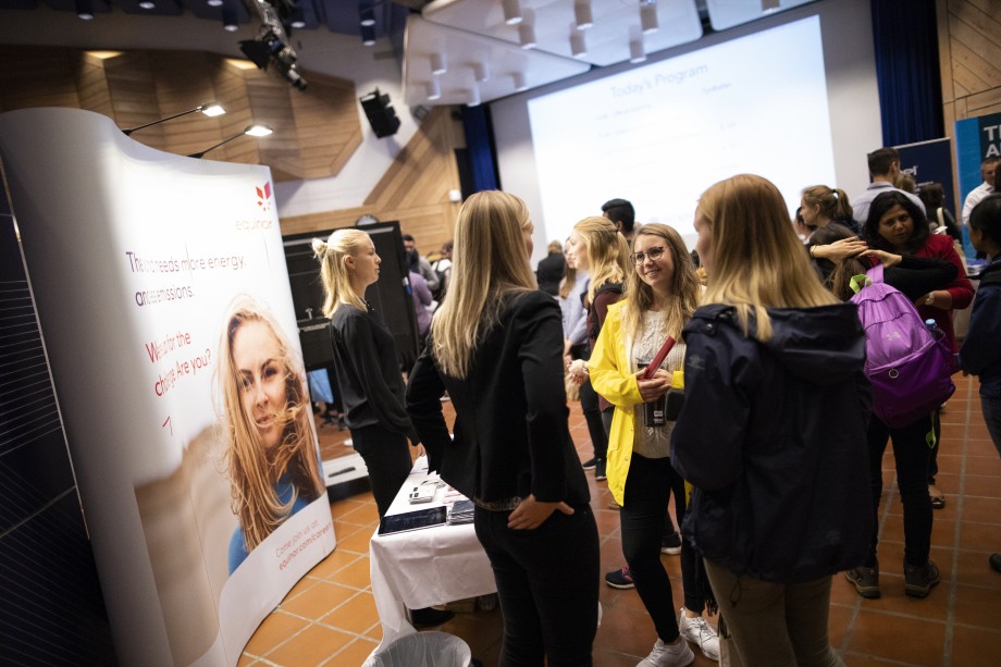 Messeområdet inne i Tjodhallen. En gruppe studenter står mot hverandre og snakker.
