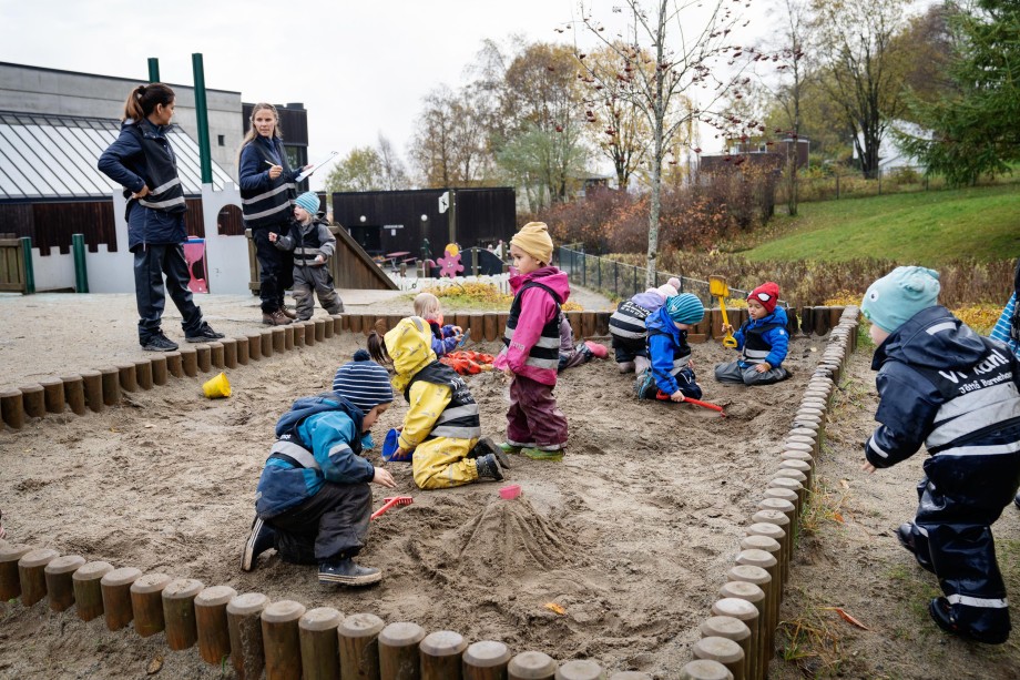 Barnehagebarn leker i sandkasse.