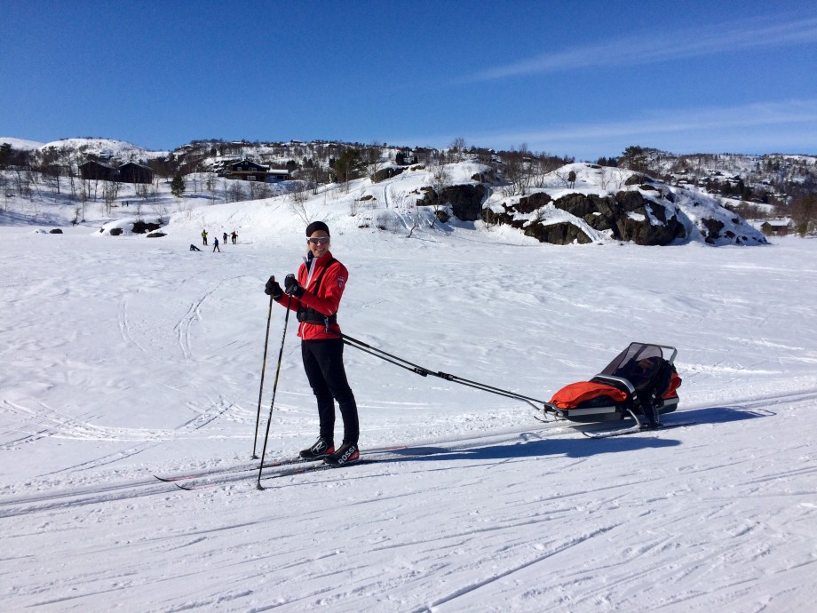 Stine Ravndal Nygård på ski med pulk bak seg. 