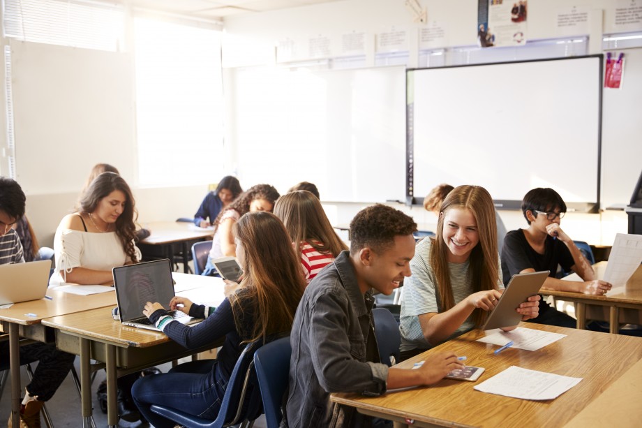 Bildet viser klasserom med elever som jobber i mindre grupper og en og en.