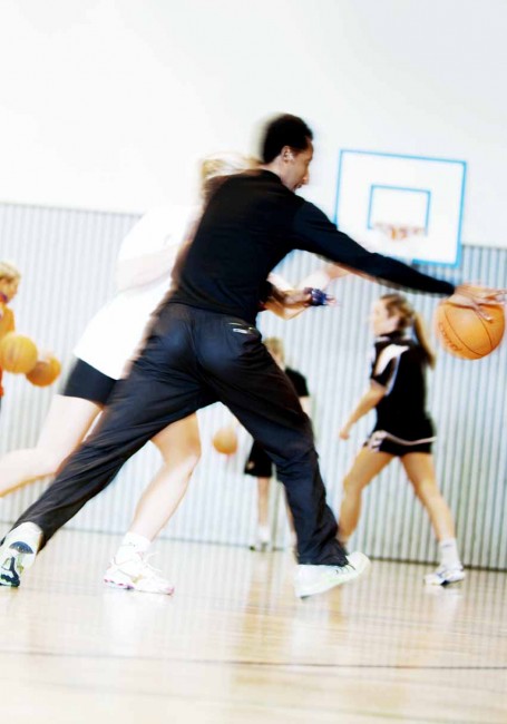 Ung mann spiller basketball innendørs