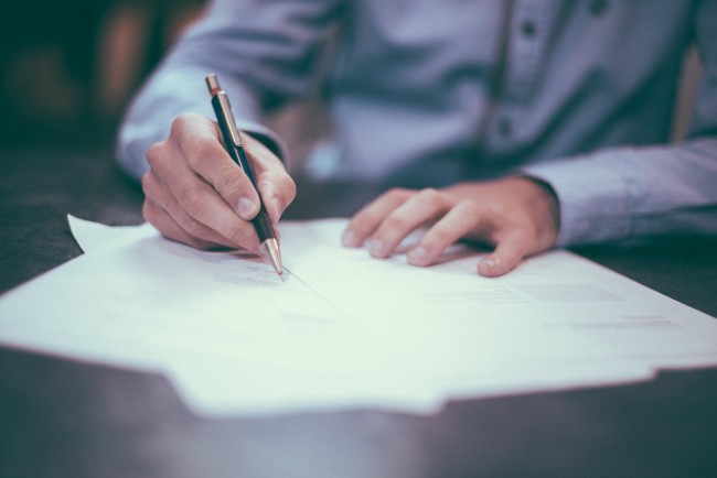 Man writing on paper - Photo by Scott Graham
