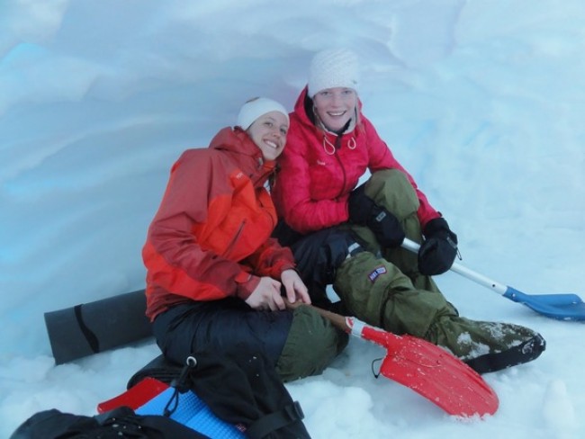Picture of two girls sitting down in the snow.