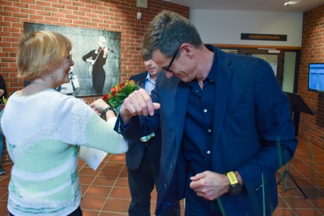 Bibliotekdirektør Gitte Kolstrup og rektor Klaus Mohn hilser på hverandre og tar hensyn til smittevern