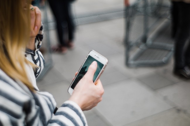 Kvinne med mobiltelefon i bymiljø