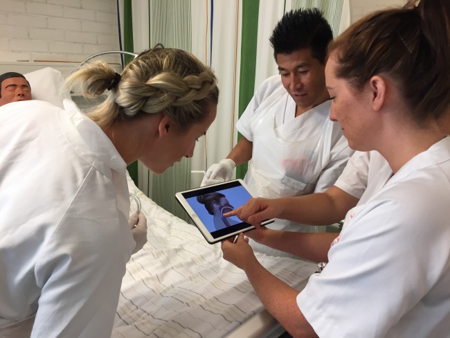 studenter ser på ferdighetsfilm i sykepleielab