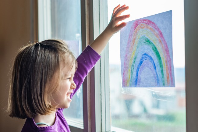 Jente som ser på tegning av regnbue