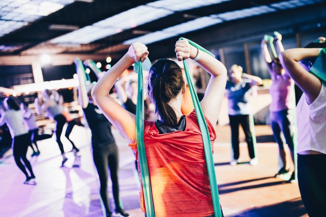En gruppe mennesker trener med treningsstrikk i en gymsal