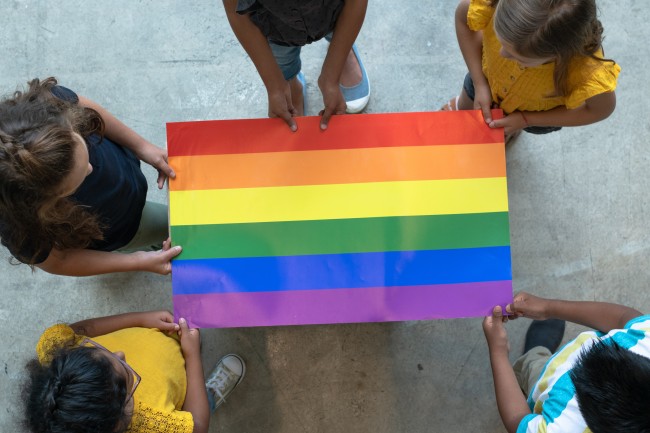 Ungdommer holder regnbueflagg