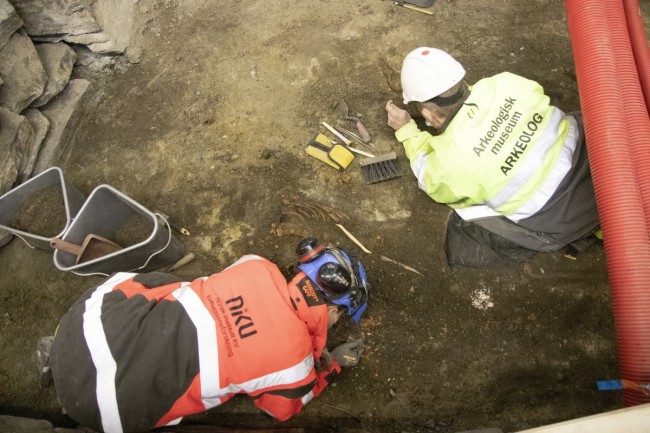 Arkeologene Sean Denham fra Arkeologisk Museum og Jani Cusevic renser graver i Stavanger Domkirke