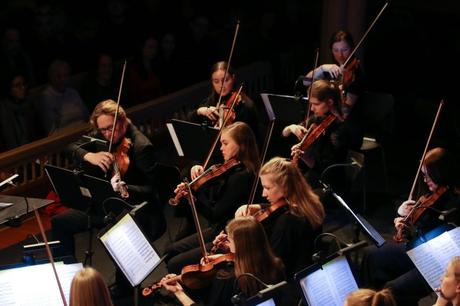 Bilde av 7 mennesker som spiller fiolin under en kammerkonsert.