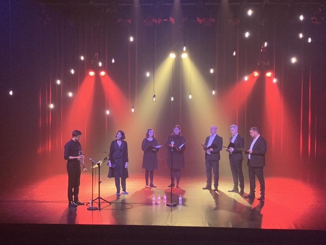 7 personer på en scene som synger