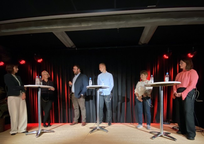 Gruppe som snakker på scene.