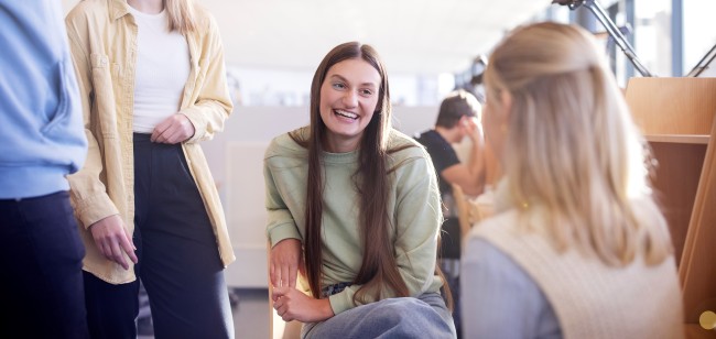 Fire studenter som sitter på en lesesal.