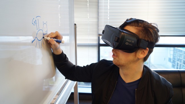 Mann med VR-briller skriver på en tavle