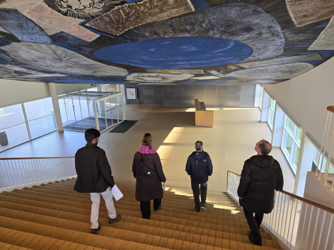 People walking down wide stairs into a large open hall