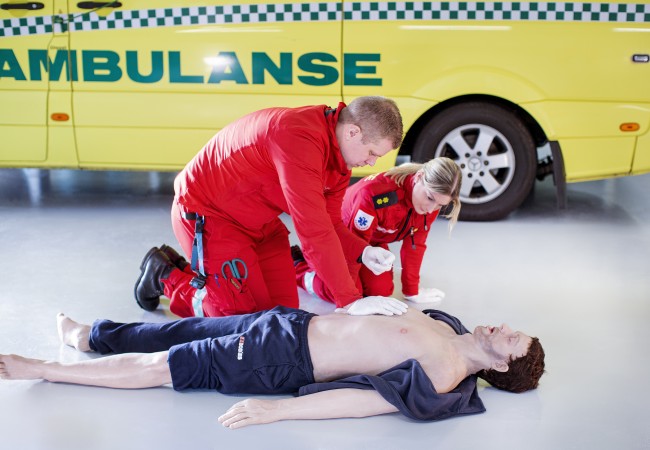 Ambulansearbeidere under ferdighetstrening med traumedukke